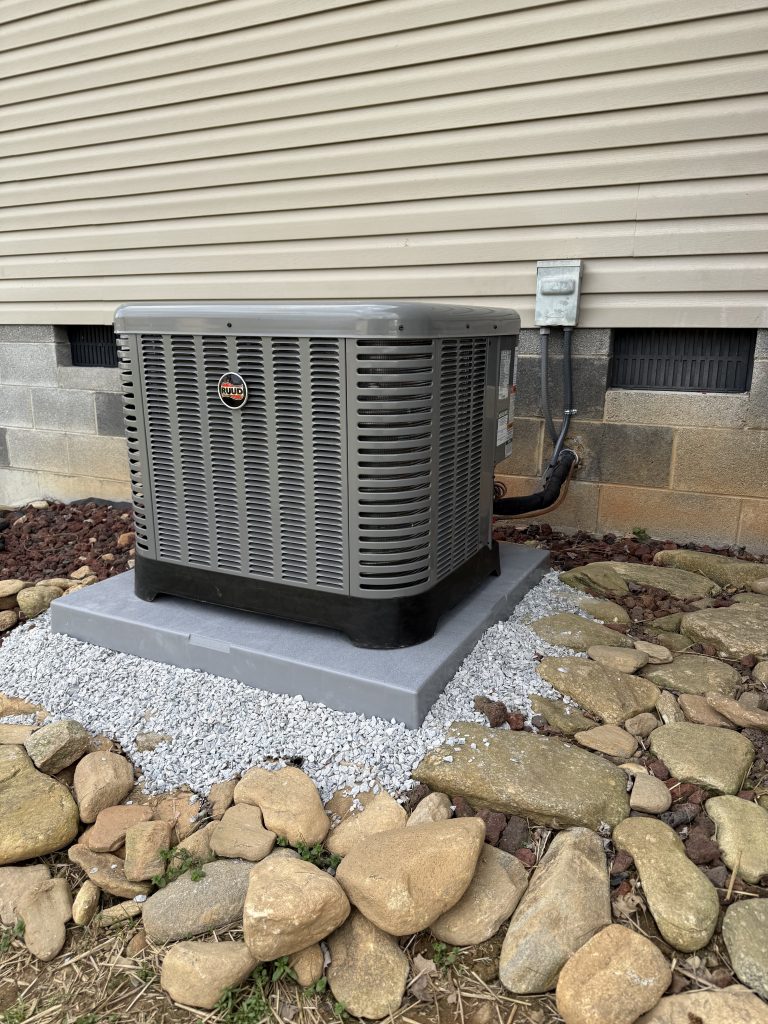New outdoor air conditioning condenser set on a fresh gravel pad